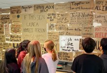 Students looking at sign about homelessness