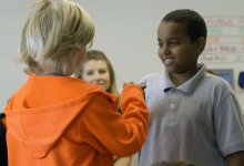 Two students fist bumping during circle practice at Valor Academy.