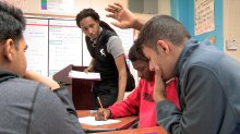 Teacher helping students in classroom at Pearl Cohn High School.