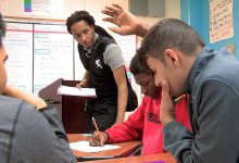 Teacher helping students in classroom at Pearl Cohn High School.