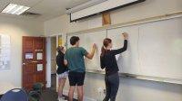 Photo of high school students at board in classroom