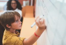 Photo of middle school student doing math on board