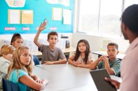 Student raising his hand in classroom