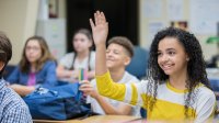 Photo of high school student raising hand in classroom