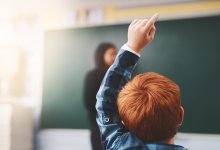 Photo of an elementary school boy raising his hand