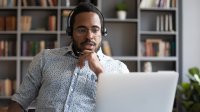 Man attends video chat on his laptop while wearing headphones