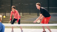 Two high school students playing pickelball