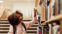 Photo of middle school student choosing book in library