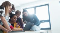 Photo of high school students looking at computer