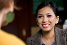 Smiling woman talks to a colleague