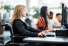 Female student in wheelchair working at computer station