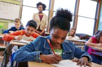 A classroom full of kids drawing one-pager assignments