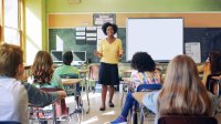 Middle school teacher walking between student's desks