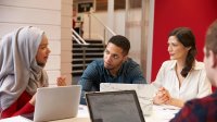 Photo of teachers meeting with their computers