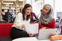 A teacher and a principal discuss the teacher's evaluation in the school library