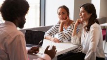 A teacher, student, and parent engaged in a parent-teacher conference