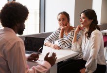 A teacher, student, and parent engaged in a parent-teacher conference