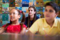 Smart Girl Listening to Teacher At School