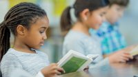 Photo of elementary students reading book in class