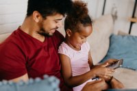 Young family online learning together on a portable computer.