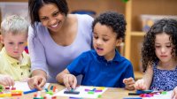 Pre- k teacher with students play with blocks in classroom