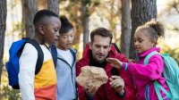 photo of elementary teacher and students working on project outside