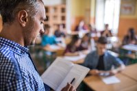 A teacher reading aloud to his middle school students