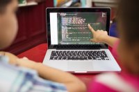 Students studying code on a laptop