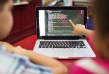 Students studying code on a laptop