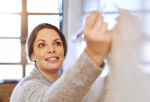 Teacher writing on whiteboard. 