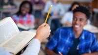 High school teacher with book in front of class