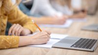 Student taking notes in class. 