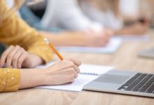 Student taking notes in class. 