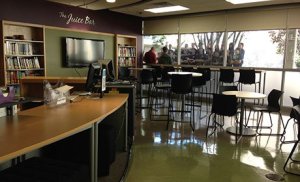 A photo of a modern juice bar, with tables and chairs spread throughout.