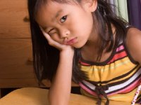 Young girl resting her head in her hand looking perplexed