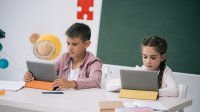 Photo of elementary students reading on tablets