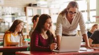 Photo of high school teacher working with a student