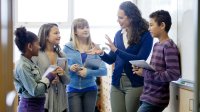 A teacher has a friendly chat with a small group of her students.