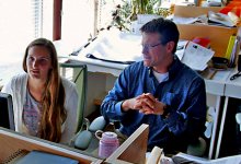 Student listening to a man explain something at the computer in an architect's office