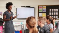 Middle school teacher speaking to students in classroom