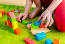 Child plays with wooden blocks on floor