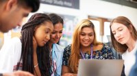 Photo of high school teacher and student looking at computer