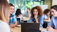 Students at a learning station discuss an assignment.