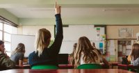 High school student raises hand and asks lecturer a question. 