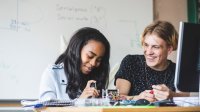 Photo of high school students working on robotics project in classroom