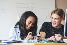 Photo of high school students working on robotics project in classroom