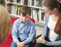 Young boy and his mother having a conference with his teacher