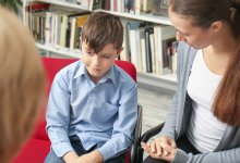 Young boy and his mother having a conference with his teacher