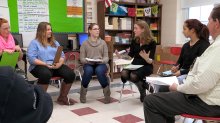 Two teachers are facilitating a circle discussion with students.