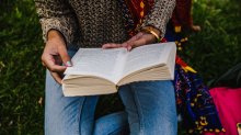 A teenage girl reads in a park